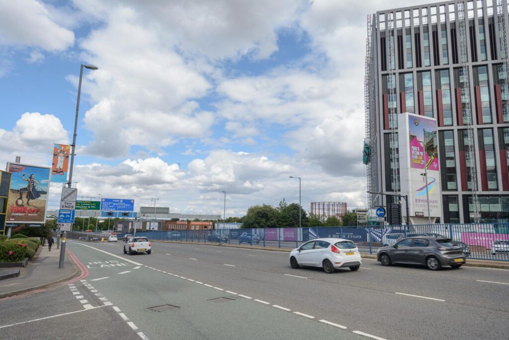 Large billboard advertising the Commonwealth Games at the side of a busy Birmingham road