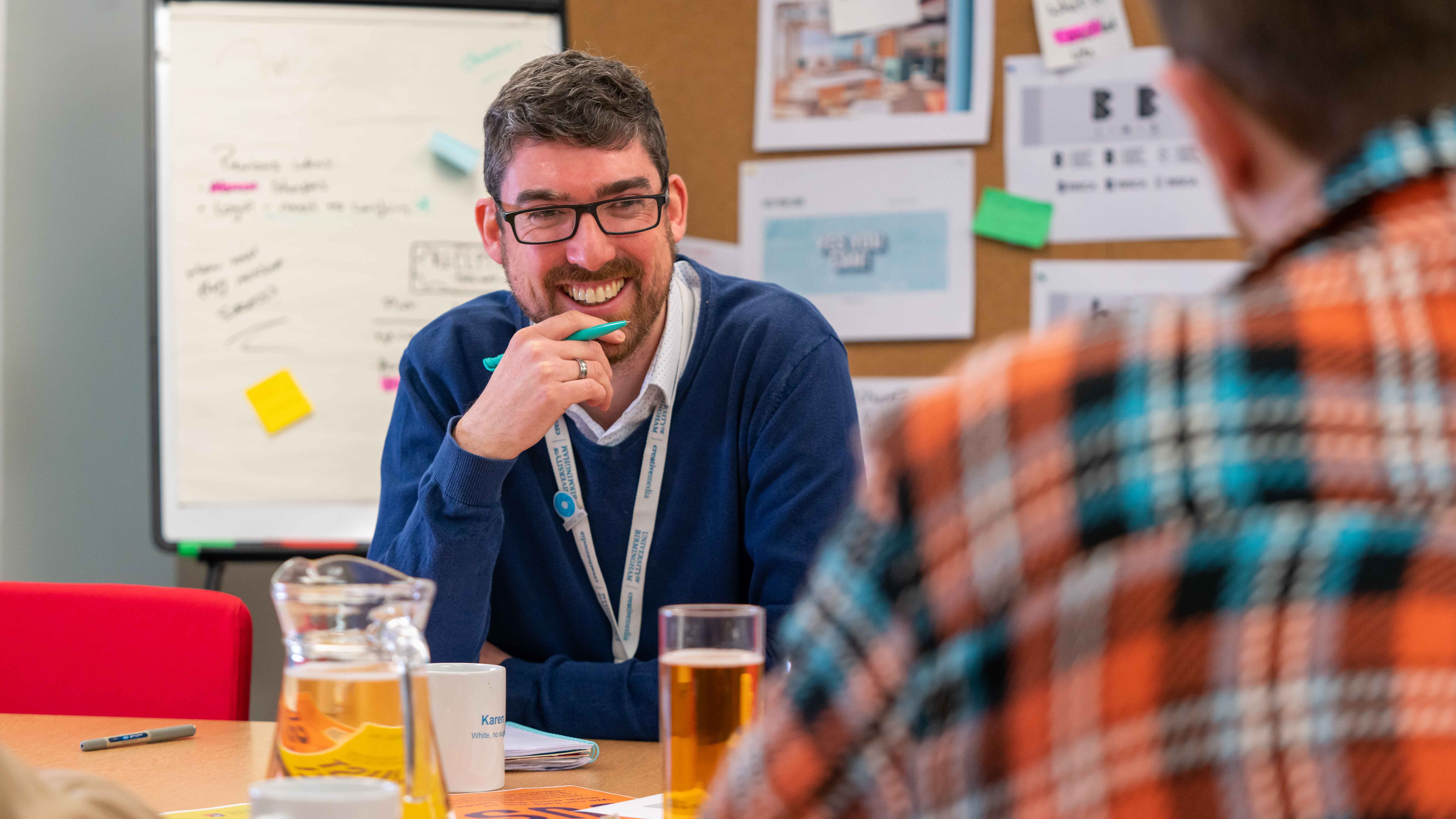 Image of an account manager at Creative Media smiling over a meeting table