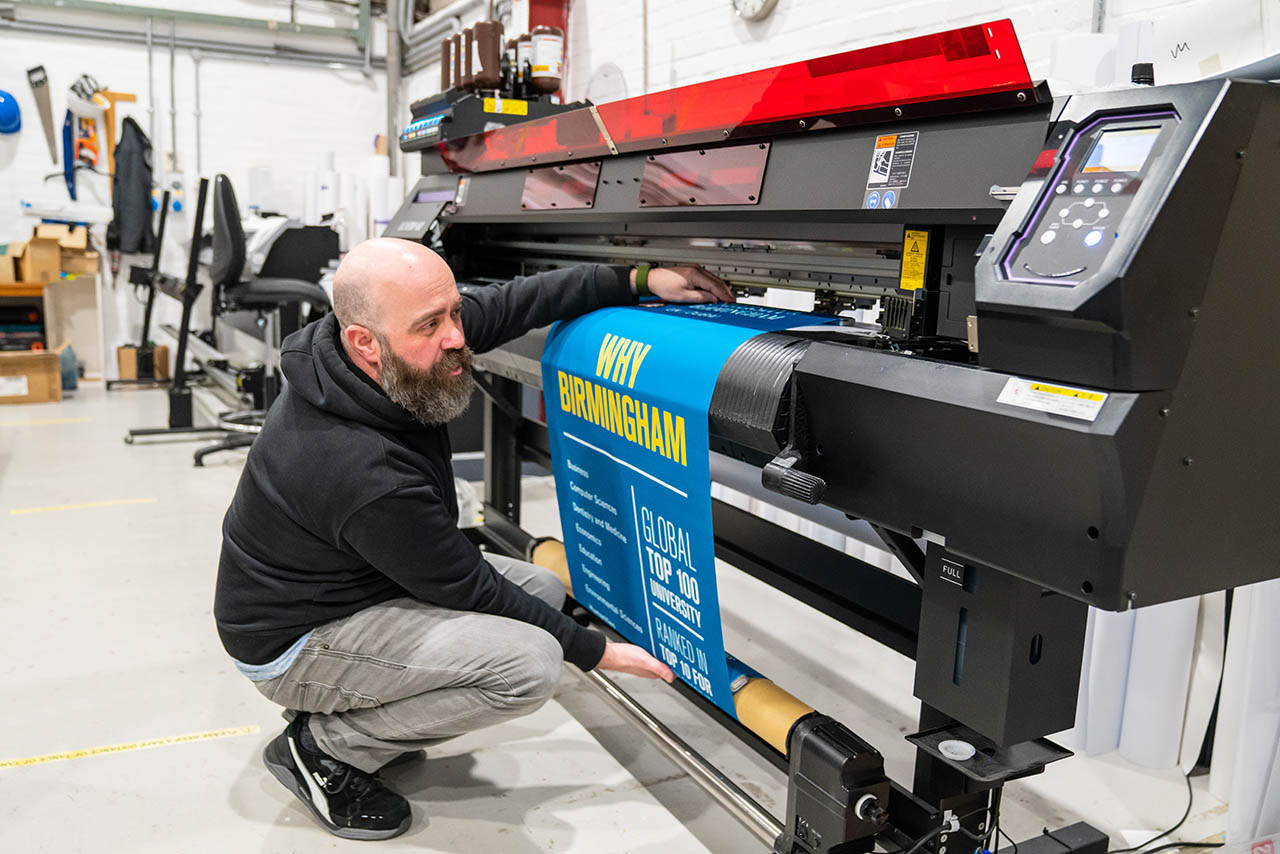 A member of the print team operating a large format printer